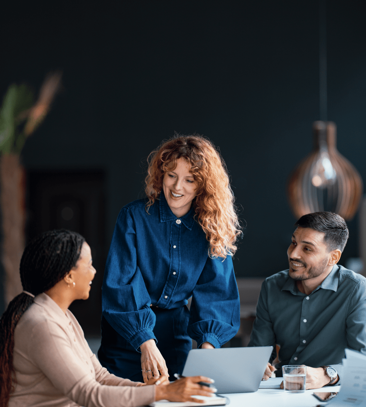 Three people having a discussion at table.